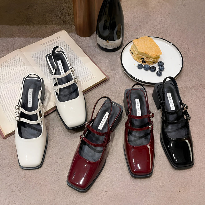 Image de cinq chaussures à talons carrés vernies de marques UNI DSH en blanc, bordeaux et noir, disposées sur un tapis, avec un livre ouvert, une bouteille de vin Moscato et une assiette de gâteau aux myrtilles en arrière-plan., 45286704775349,45286704808117,45286704840885,45286704873653,45286704906421,45286704939189,45286704971957,45286705004725,45286705037493,45286705070261,45286705103029,45286705135797,45286705168565,45286705201333,45286705234101,45286705266869,45286705299637,45286705332405