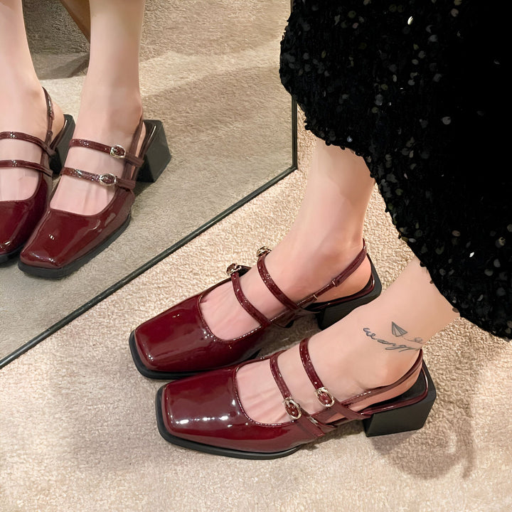 Gros plan sur des chaussures vernies bordeaux à talons bloc portées. On voit les brides multiples avec des boucles dorées et un tatouage discret sur la cheville. Reflet du miroir visible., 45286704775349,45286704808117,45286704840885,45286704873653,45286704906421,45286704939189,45286704971957,45286705004725,45286705037493,45286705070261,45286705103029,45286705135797,45286705168565,45286705201333,45286705234101,45286705266869,45286705299637,45286705332405