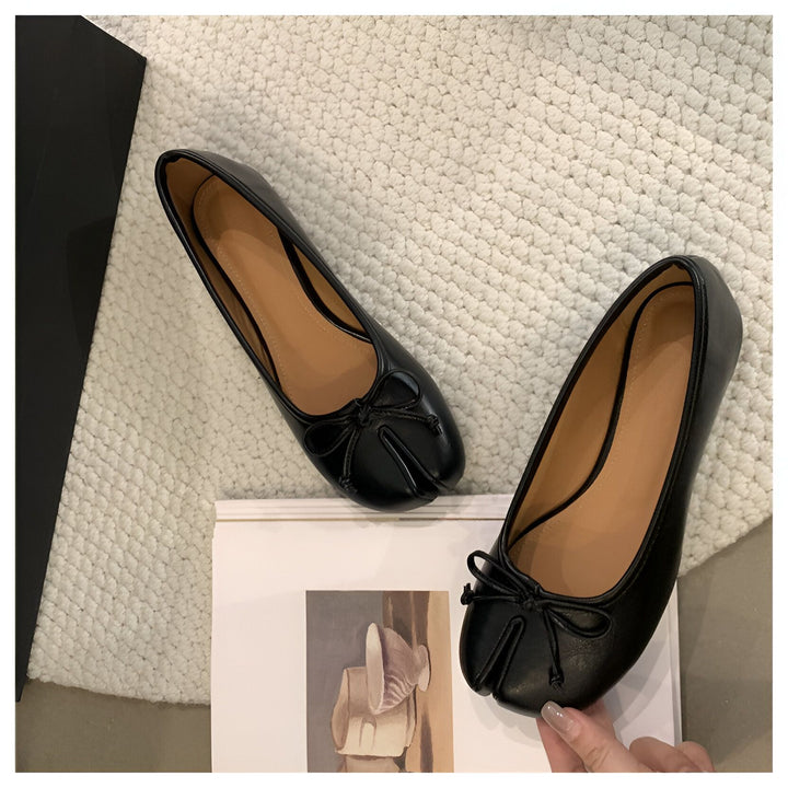 Image de deux ballerines noires en cuir avec un nœud décoratif sur le dessus, placées sur un tapis blanc et un livre. Chaussures élégantes pour femmes. Mode et style., 45286631932085,45286631964853,45286631997621,45286632030389,45286632063157,45286632095925,45286632128693,45286632161461,45286632194229,45286632226997,45286632259765,45286632292533,45286632325301,45286632358069,45286632390837,45286632423605,45286632456373,45286632489141,45286632521909,45286632554677,45286632587445,45286632620213,4528663