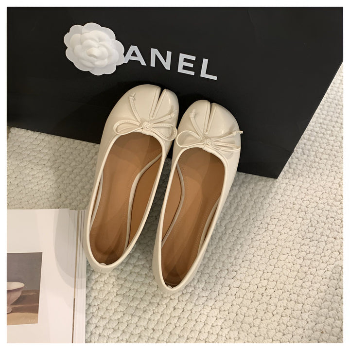 Paire d'élégantes ballerines blanches vernies, avec un nœud délicat, posées devant un sac de marque noir orné d'une fleur blanche. Chaussures de luxe et accessoires de mode., 45286631932085,45286631964853,45286631997621,45286632030389,45286632063157,45286632095925,45286632128693,45286632161461,45286632194229,45286632226997,45286632259765,45286632292533,45286632325301,45286632358069,45286632390837,45286632423605,45286632456373,45286632489141,45286632521909,45286632554677,45286632587445,45286632620213