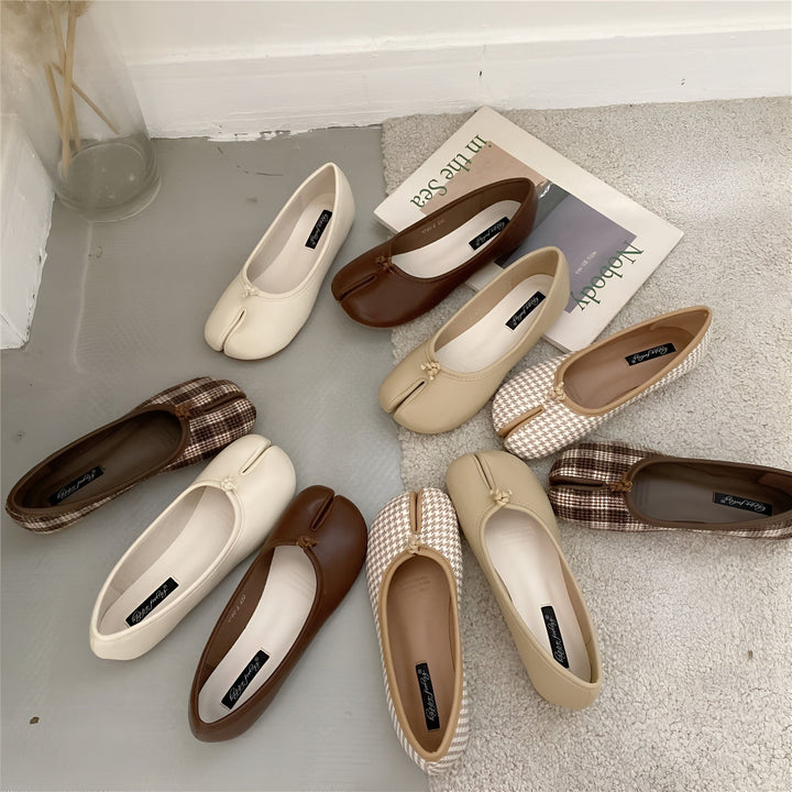 Vue rapprochée de plusieurs paires d'élégantes ballerines à bout fendu, en cuir beige, marron et à motifs, disposées sur un tapis texturé. Un vase transparent et un magazine avec du texte visible ajoutent une touche décorative., 45286633865397,45286633898165,45286633930933,45286633963701,45286633996469,45286634029237,45286634062005,45286634094773,45286634127541,45286634160309,45286634193077,45286634225845,45286634258613,45286634291381,45286634324149,45286634356917,45286634389685,45286634422453,452