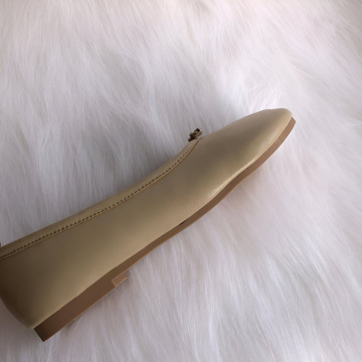 Vue rapprochée d'une ballerine beige à bout carré, posée sur un fond blanc duveteux. La chaussure présente une semelle plate marron et un petit nœud décoratif. Idéale pour un look décontracté et élégant., 45286633865397,45286633898165,45286633930933,45286633963701,45286633996469,45286634029237,45286634062005,45286634094773,45286634127541,45286634160309,45286634193077,45286634225845,45286634258613,45286634291381,45286634324149,45286634356917,45286634389685,45286634422453,45286634455221,45286634