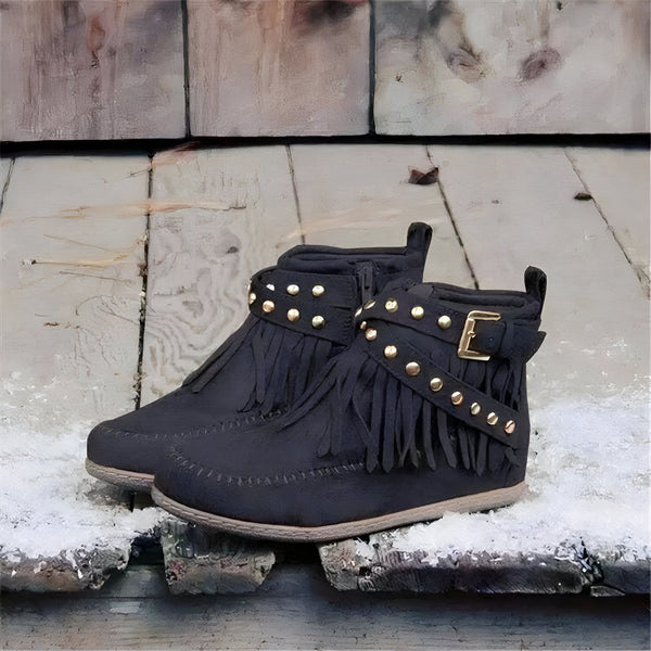 Paire de bottines noires à franges et clous dorés, avec une boucle sur le côté, présentées sur un fond rustique en bois. Chaussures style mocassins indiens, tendance bohème., 45286979731637,45286979764405,45286979797173,45286979829941,45286979862709,45286979895477,45286979928245,45286979961013,45286979993781,45286980026549,45286980059317,45286980092085,45286980124853,45286980157621,45286980190389,45286980223157,45286980255925,45286980288693,45286980321461,45286980354229,45286980386997,4528698041976