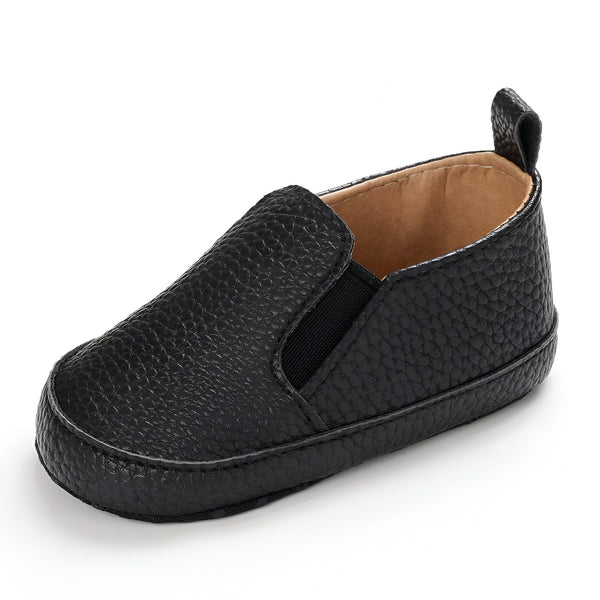 Chaussure de bébé noire en cuir, style mocassin avec élastique sur le dessus du pied et languette arrière. Vue rapprochée., 45286821560501,45286821593269,45286821626037,45286821658805,45286821691573,45286821724341,45286821757109,45286821789877,45286821822645,45286821855413,45286821888181,45286821920949,45286821953717,45286821986485,45286822019253,45286822052021,45286822084789,45286822117557