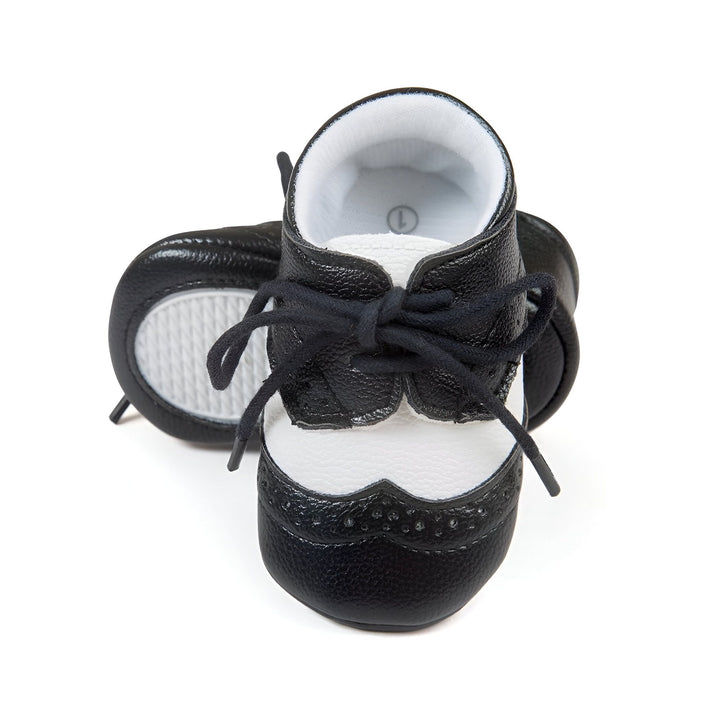 Chaussures de bébé bicolores, noir et blanc, style derby avec lacets noirs sur fond blanc. Chaussures élégantes pour les premiers pas de bébé., 45286817824949,45286817857717,45286817890485,45286817923253,45286817956021,45286817988789,45286818021557,45286818054325,45286818087093,45286818119861,45286818152629,45286818185397