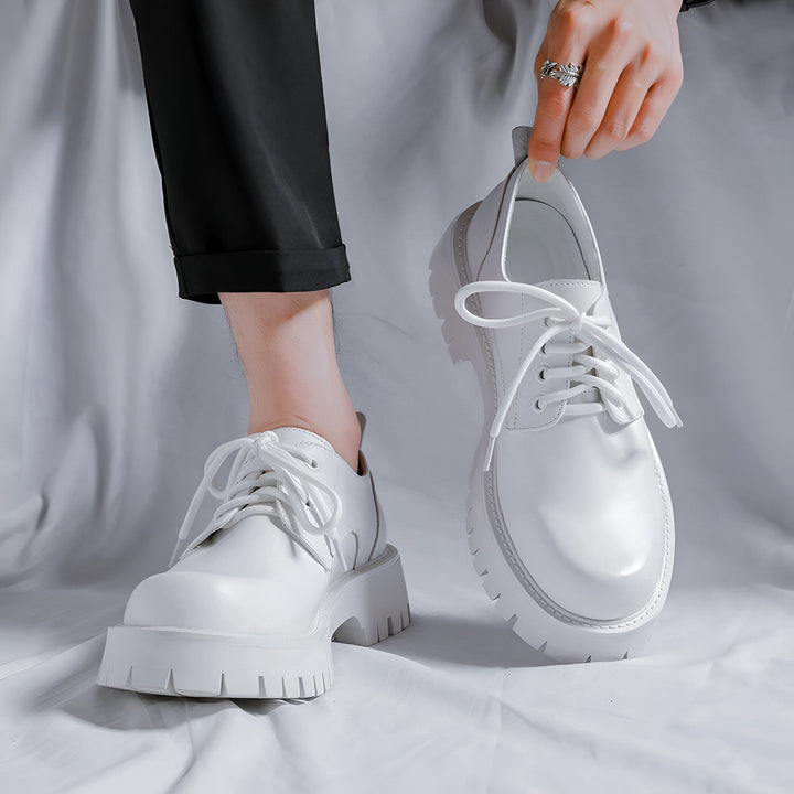 Gros plan de chaussures derby blanches à semelle épaisse. Style mode unisexe, tenue décontractée. Détails: lacets blancs, pantalon noir. Présentation élégante avec une bague argentée à la main., 45286883492021,45286883524789,45286883557557,45286883590325,45286883623093,45286883655861,45286883688629,45286883721397,45286883754165,45286883786933,45286883819701,45286883852469,45286883885237,45286883918005,45286883950773,45286883983541,45286884016309,45286884049077,45286884081845,45286884114613,45286