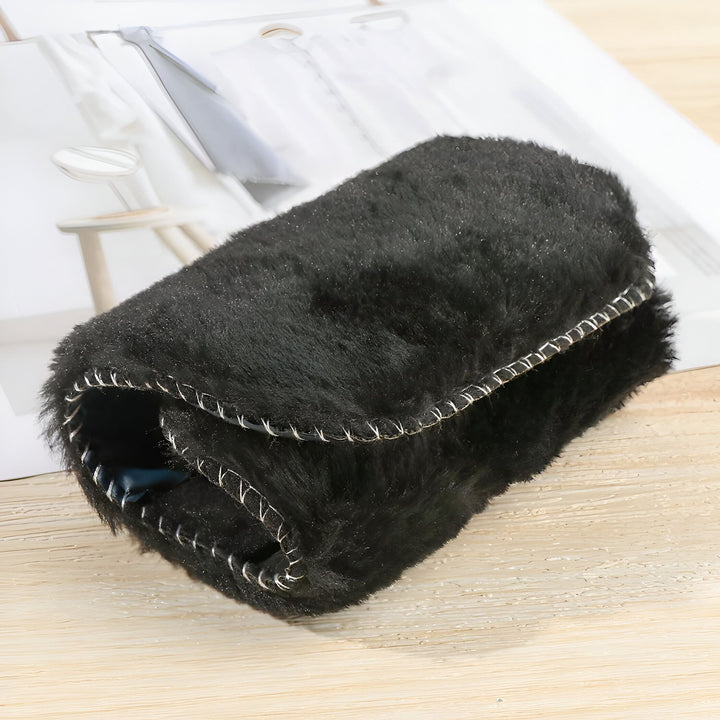 Pochette noire en fausse fourrure, bordée de surpiqûres décoratives. Accessoire de mode hivernal, style et confort., 45286864978101