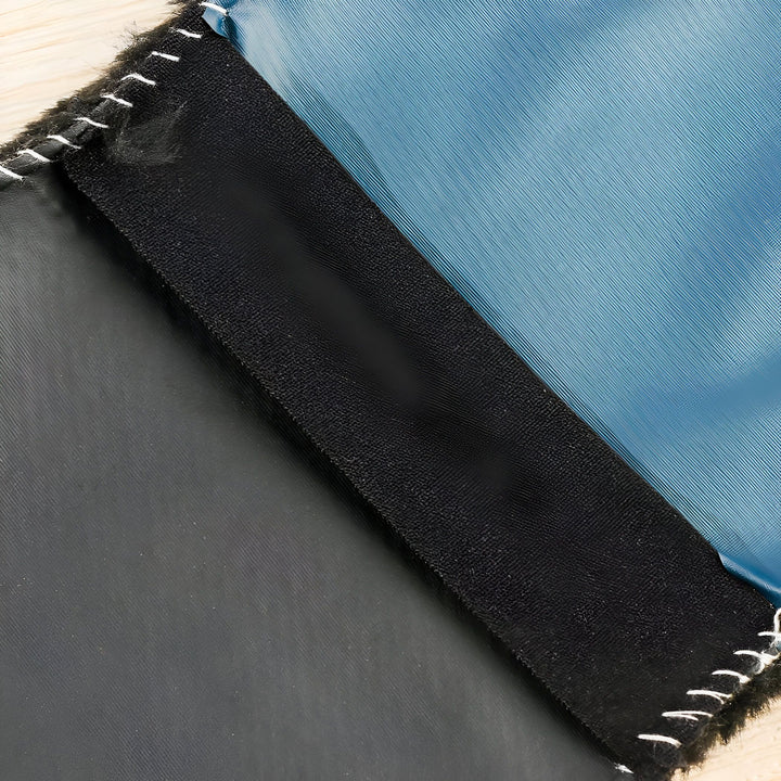 Image rapprochée de différents tissus cousus ensemble : noir, bande noire texturée et bleu satiné, avec des coutures blanches apparentes., 45286864978101