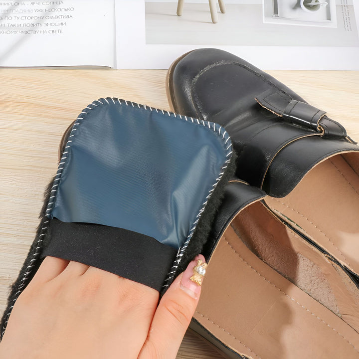 Gros plan de mocassins noirs, l'un avec un embauchoir bleu à l'intérieur, une main ajustant le chausse-pied. Chaussures de cuir confortables., 45286864978101