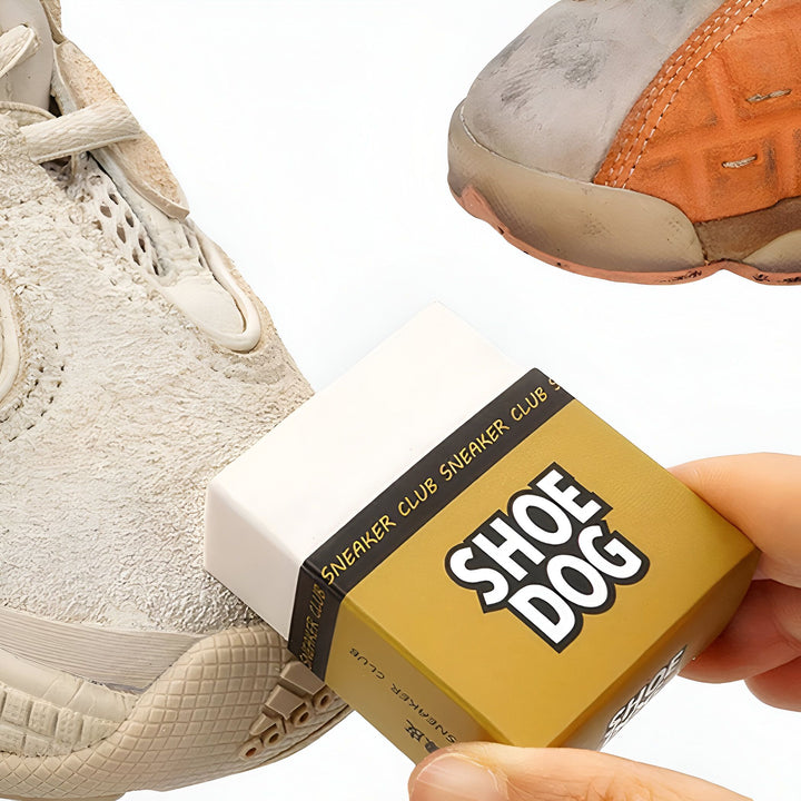 Gomme de nettoyage pour chaussures Sneaker Club "Shoe Dog" tenue par une main, entourée de chaussures sales. Solution efficace pour nettoyer et redonner de l'éclat à vos baskets., 45286736560309