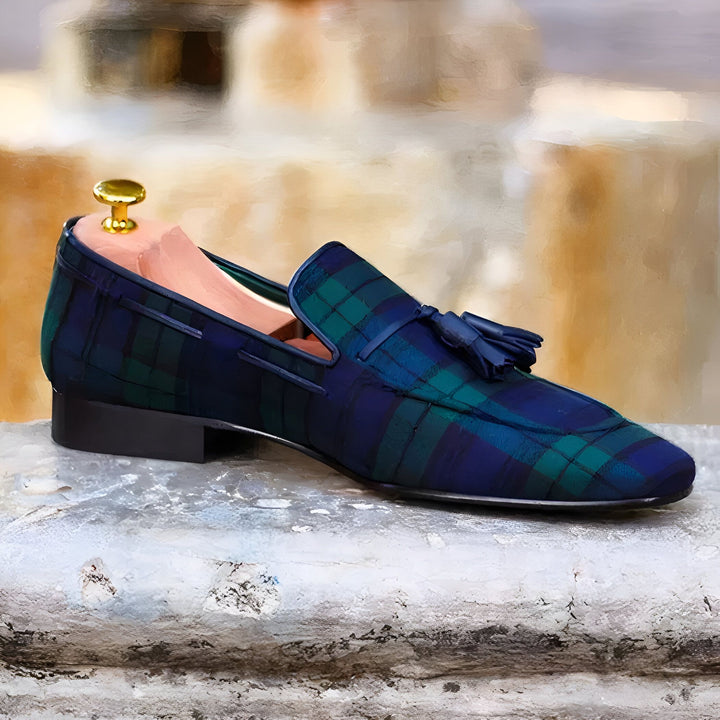 Mocassin homme à carreaux bleu et vert avec pompon, posé sur une surface texturée claire, forme de soulier visible., 45286848397493,45286848430261,45286848463029,45286848495797,45286848528565,45286848561333,45286848594101