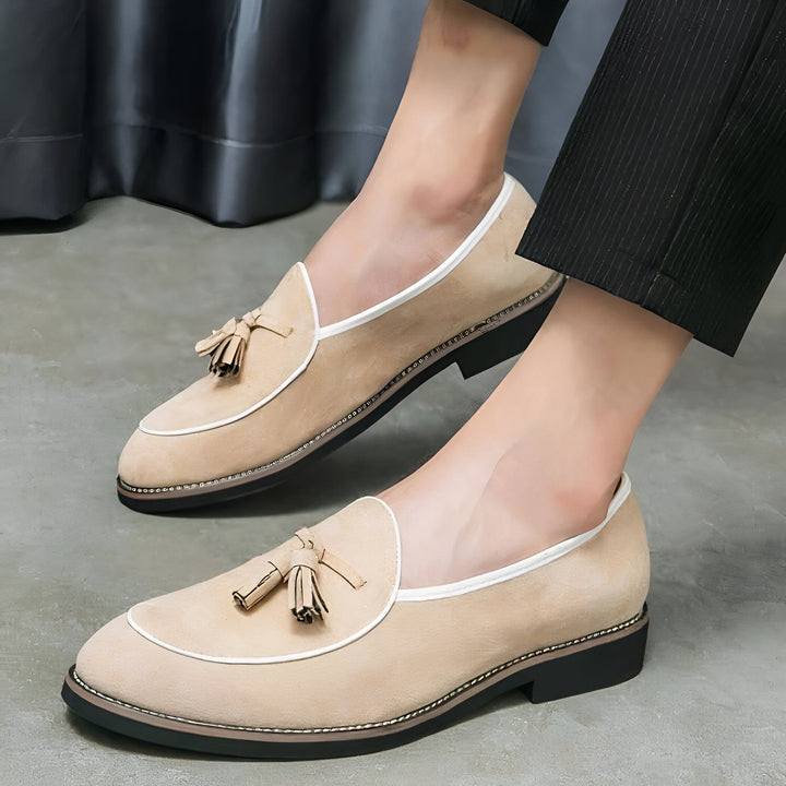 Gros plan sur une paire de mocassins à glands beiges élégants portés avec un pantalon noir. Chaussures classiques en daim, bordure blanche. Idéal pour une tenue décontractée chic ou professionnelle. Mode masculine, style moderne., 45286933266613,45286933299381,45286933332149,45286933364917,45286933397685,45286933430453,45286933463221,45286933495989,45286933528757,45286933561525,45286933594293,45286933627061,45286933659829,45286933692597,45286933725365,45286933758133,45286933790901,45286933823669,45