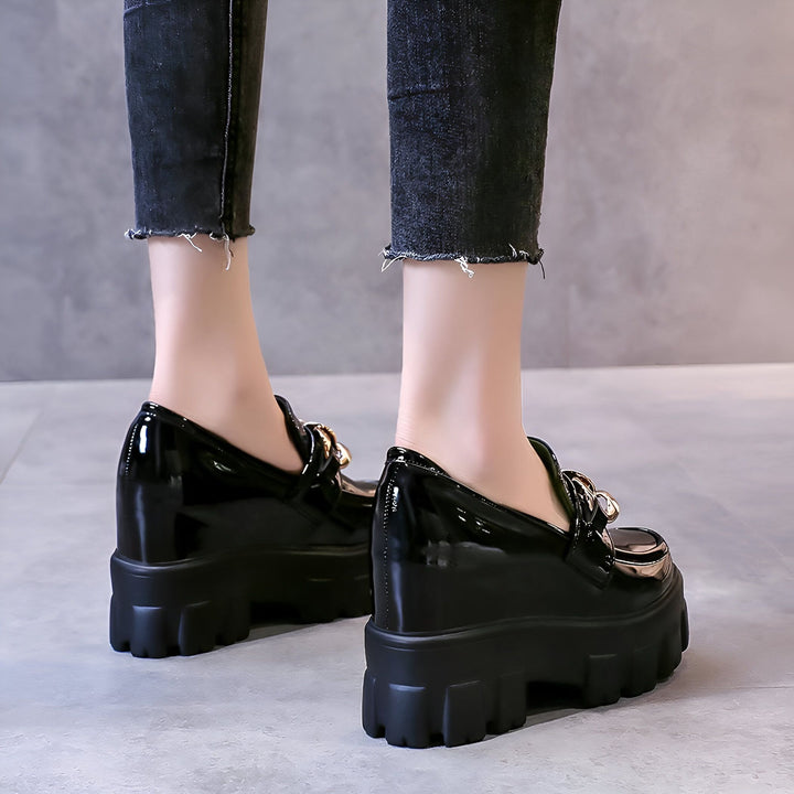 Gros plan sur des chaussures à plateforme vernies noires avec ornement doré, portées avec un jean noir effiloché. Idéal pour la mode et les tendances., 45286934839477,45286934872245,45286934905013,45286934937781,45286934970549,45286935003317,45286935036085,45286935068853,45286935101621,45286935134389,45286935167157,45286935199925