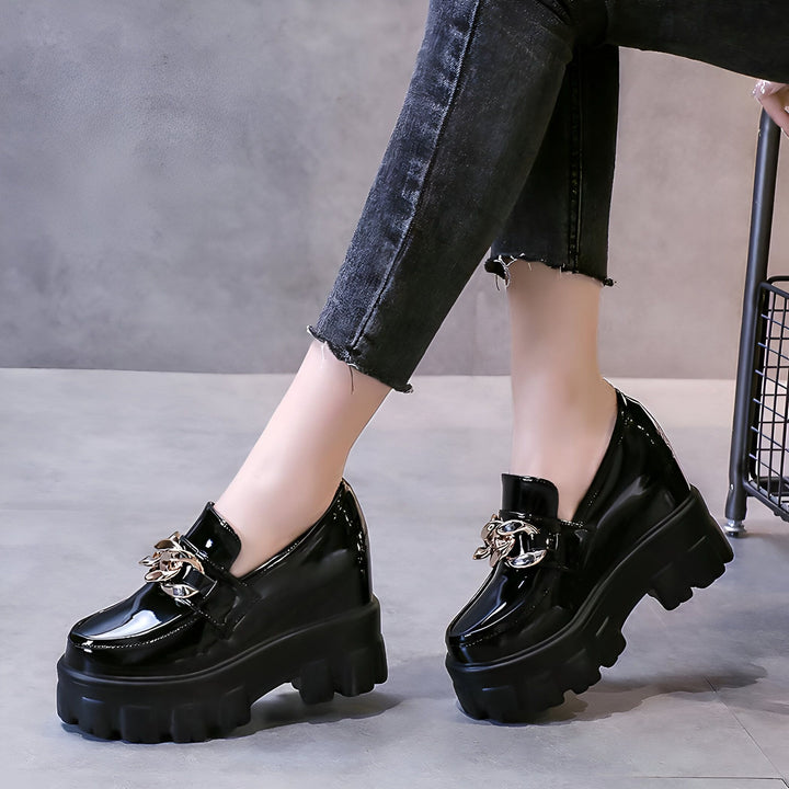 Gros plan de mocassins noirs vernis à plateforme, ornés de chaînes dorées, portés avec un jean noir. Chaussures tendance et audacieuses., 45286934839477,45286934872245,45286934905013,45286934937781,45286934970549,45286935003317,45286935036085,45286935068853,45286935101621,45286935134389,45286935167157,45286935199925