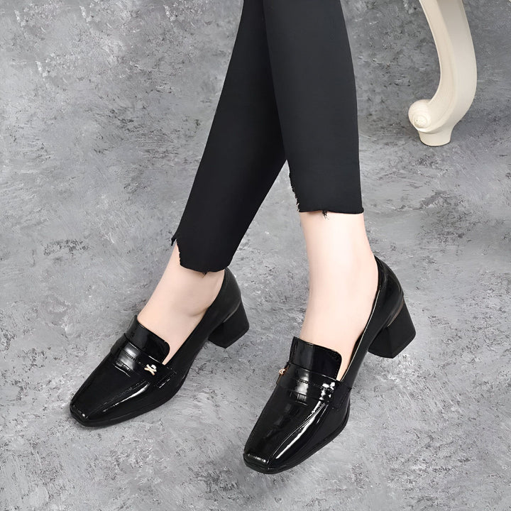Femme portant des chaussures mocassins noires vernies à talons carrés avec un legging noir. Chaussures élégantes et confortables., 45286873890997,45286873923765,45286873956533,45286873989301,45286874022069,45286874054837,45286874087605,45286874120373,45286874153141,45286874185909,45286874218677,45286874251445
