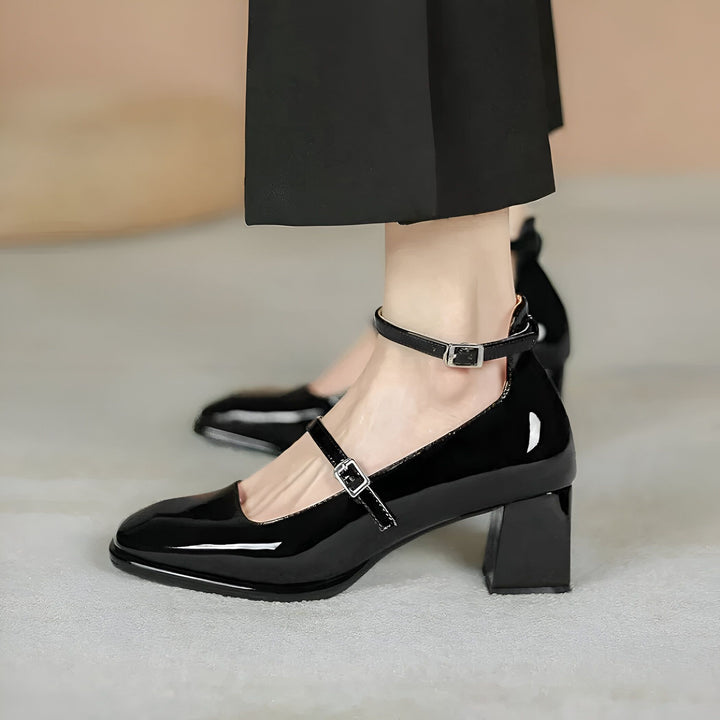 Gros plan sur des chaussures Mary Jane noires vernies avec talons carrés, portées avec un pantalon noir. Sangle à boucle autour de la cheville et sur le cou-de-pied. Style élégant et rétro., 45286705823925,45286705856693,45286705889461,45286705922229,45286705954997,45286705987765,45286706020533,45286706053301,45286706086069,45286706118837,45286706151605,45286706184373,45286706217141,45286706249909,45286706282677