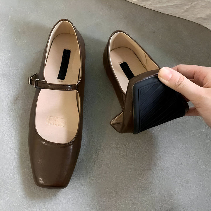 Chaussures Mary Jane marron avec bride. Une main soulève une chaussure pour montrer sa semelle noire et son talon carré. Mode féminine, chaussures confortables, style rétro., 45286707134645,45286707167413,45286707200181,45286707232949,45286707265717,45286707298485,45286707331253,45286707364021,45286707396789,45286707429557,45286707462325,45286707495093,45286707527861,45286707560629,45286707593397,45286707626165,45286707658933,45286707691701,45286707724469,45286707757237