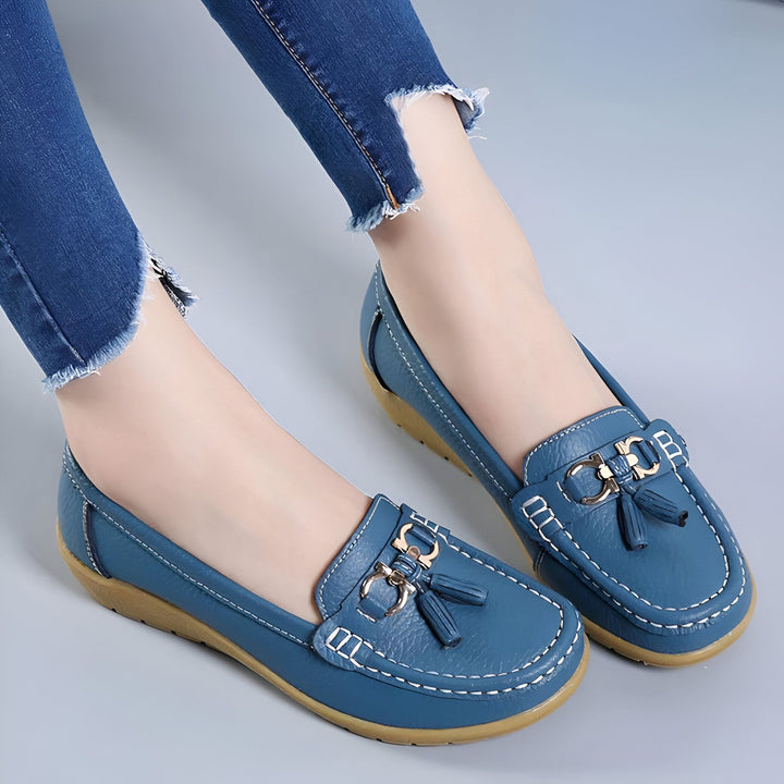 Gros plan de mocassins bleus en cuir sur des pieds portant un jean bleu. Les chaussures présentent des détails de couture blanche et une décoration avec des glands et une boucle., 45287140950197,45287140982965,45287141015733,45287141048501,45287141081269,45287141114037,45287141146805,45287141179573,45287141212341,45287141245109,45287141277877,45287141310645,45287141343413,45287141376181,45287141408949,45287141441717,45287141474485,45287141507253,45287141540021,45287141572789,45287141605557,452871416383
