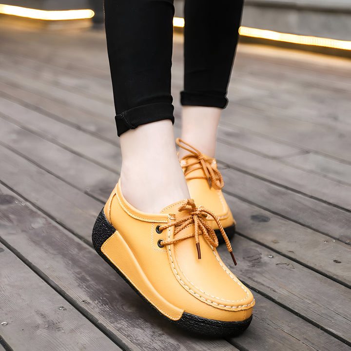 Gros plan de chaussures bateau en cuir jaune portées avec un legging noir. Chaussures à lacets marron et semelle compensée noire. Vue sur un sol en bois clair., 45286815301813,45286815334581,45286815367349,45286815400117,45286815432885,45286815465653,45286815498421,45286815531189,45286815563957,45286815596725,45286815629493,45286815662261,45286815695029,45286815727797,45286815760565,45286815793333,45286815826101,45286815858869,45286815891637,45286815924405,45286815957173,45286815989941,45286816022709,4