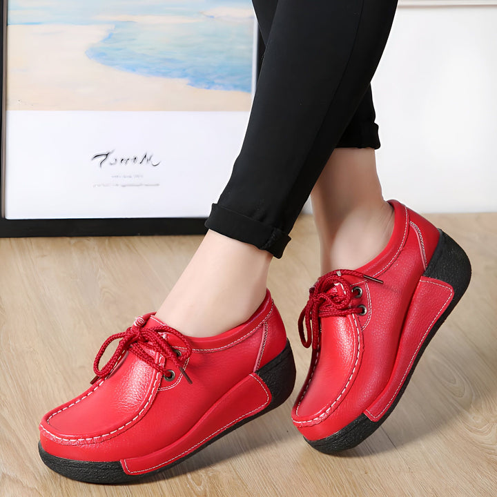 Gros plan de chaussures rouges en cuir à lacets avec semelle compensée, portées par une femme en pantalon noir., 45286815301813,45286815334581,45286815367349,45286815400117,45286815432885,45286815465653,45286815498421,45286815531189,45286815563957,45286815596725,45286815629493,45286815662261,45286815695029,45286815727797,45286815760565,45286815793333,45286815826101,45286815858869,45286815891637,45286815924405,45286815957173,45286815989941,45286816022709,45286816055477,45286816088245,45286816121013,4528