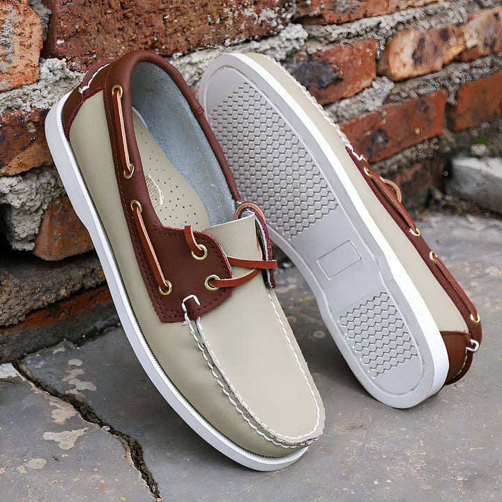 Chaussures bateau en cuir beige et marron posées sur fond de briques. Semelles antidérapantes visibles. Chaussures décontractées, mode masculine., 45286757564597,45286757597365,45286757630133,45286757662901,45286757695669,45286757728437,45286757761205,45286757793973