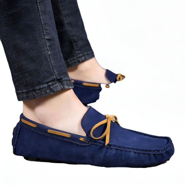 Homme portant des mocassins bleus en daim avec des lacets décoratifs en cuir marron, associés à un jean décontracté. Chaussures élégantes et confortables, idéales pour un look tendance et décontracté. Détail du nœud et couture apparente., 45286749995189,45286750027957,45286750060725,45286750093493,45286750126261,45286750159029,45286750191797,45286750224565,45286750257333,45286750290101,45286750322869,45286750355637,45286750388405,45286750421173,45286750453941,45286750486709,45286750519477,4528