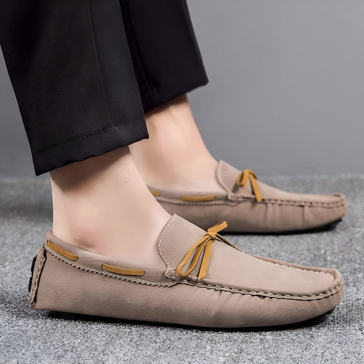Gros plan sur des mocassins pour homme en cuir suédé beige avec lacets décoratifs jaune moutarde. Pantalon noir décontracté en arrière-plan. Chaussures élégantes et confortables., 45286749995189,45286750027957,45286750060725,45286750093493,45286750126261,45286750159029,45286750191797,45286750224565,45286750257333,45286750290101,45286750322869,45286750355637,45286750388405,45286750421173,45286750453941,45286750486709,45286750519477,45286750552245,45286750585013,45286750617781,45286750650549,4528675