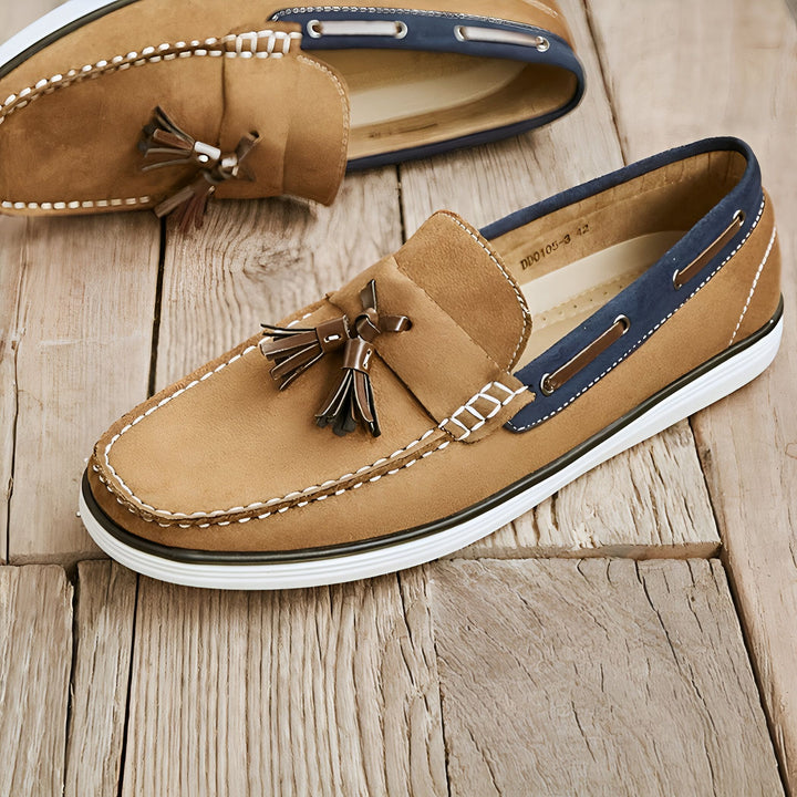 Mocassins homme en daim marron avec glands, sur un fond en bois. Chaussures décontractées, style nautique avec détails bleus et couture blanche., 45287031046325,45287031079093,45287031111861,45287031144629,45287031177397,45287031210165,45287031242933,45287031275701,45287031308469,45287031341237,45287031374005,45287031406773,45287031439541,45287031472309,45287031505077,45287031537845,45287031570613,45287031603381,45287031636149,45287031668917,45287031701685,45287031734453,45287031767221,45287031799989