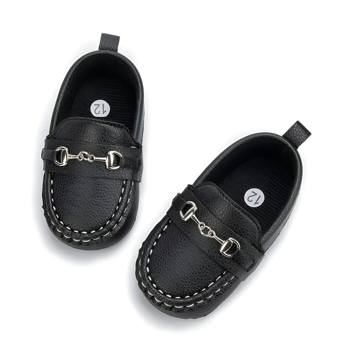 Deux mocassins noirs pour bébé, en cuir avec ornement métallique en forme de mors de cheval. Semelle intérieure avec indication de taille "12". Chaussures élégantes pour les tout-petits., 45286993789109,45286993821877,45286993854645,45286993887413,45286993920181,45286993952949,45286993985717,45286994018485,45286994051253