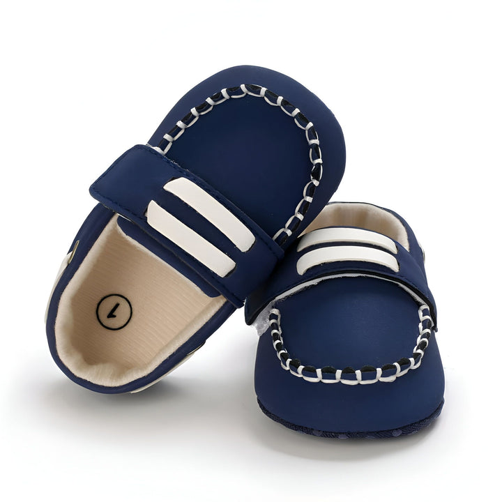 Chaussures de bébé bleu marine avec deux bandes blanches. Chaussures à semelle souple, style mocassin, avec détails de couture blanche. Idéal pour les premiers pas et les photos de bébé., 45286948929717,45286948962485,45286948995253,45286949028021,45286949060789,45286949093557,45286949126325,45286949159093,45286949191861
