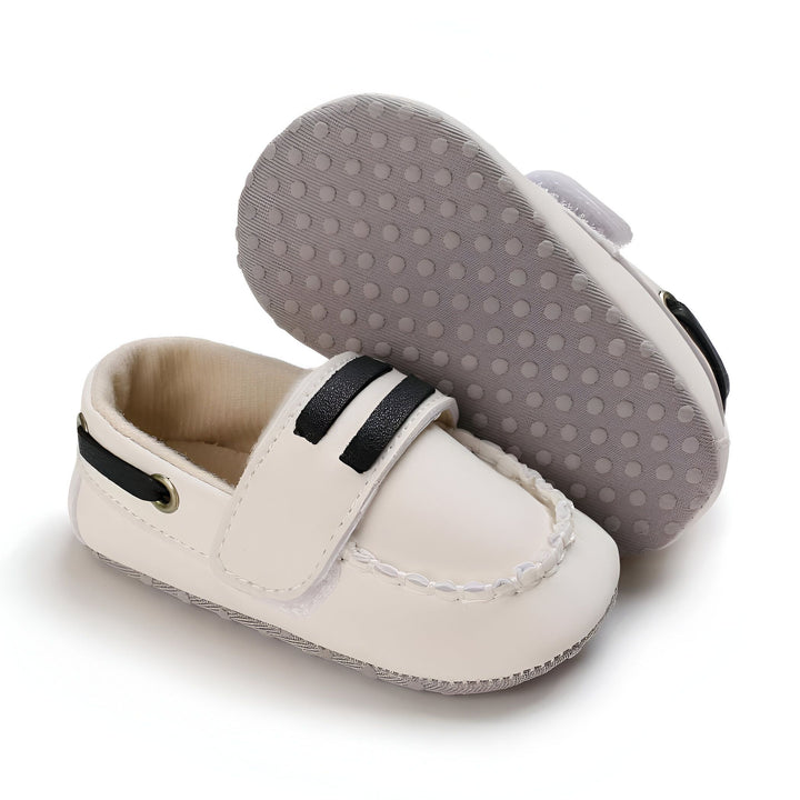 Chaussures de bébé blanches de style mocassin avec des rayures noires. Semelles antidérapantes grises pour une meilleure adhérence. Chaussures pour nouveau-né, élégantes et confortables., 45286948929717,45286948962485,45286948995253,45286949028021,45286949060789,45286949093557,45286949126325,45286949159093,45286949191861