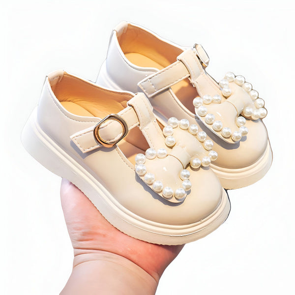 Paire d'élégantes chaussures vernies beiges pour enfant, ornées de nœuds en perles blanches. Fermeture à boucle dorée. Idéales pour une occasion spéciale ou une tenue de fête. Mode enfantine., 45287050772661,45287050805429,45287050838197,45287050870965,45287050903733,45287050936501,45287050969269,45287051002037,45287051034805,45287051067573,45287051100341,45287051133109,45287051165877,45287051198645,45287051231413,45287051264181,45287051296949,45287051329717,45287051362485,45287051395253,45287051