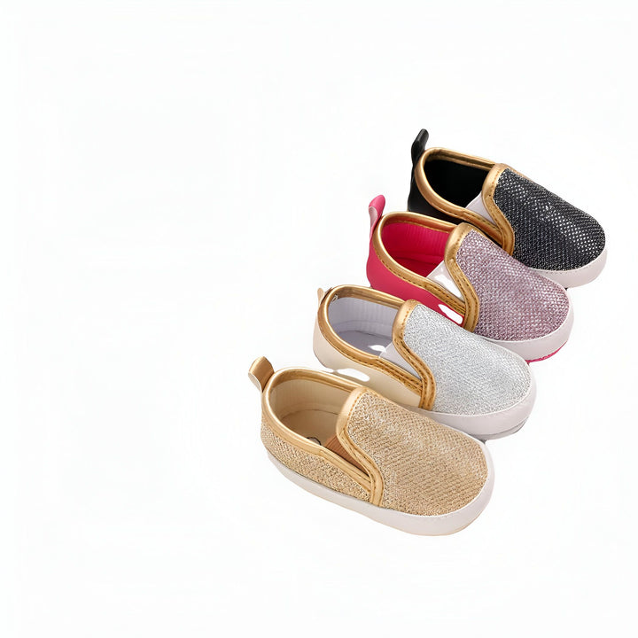 Quatre paires de chaussures pour bébés, de couleurs or, argent, rose et noir, disposées en diagonale sur un fond blanc. Chaussures à enfiler avec bordure dorée. Mode bébé, chaussures pour enfants., 45286824083637,45286824116405,45286824149173,45286824181941,45286824214709,45286824247477,45286824280245,45286824313013,45286824345781,45286824378549,45286824411317,45286824444085