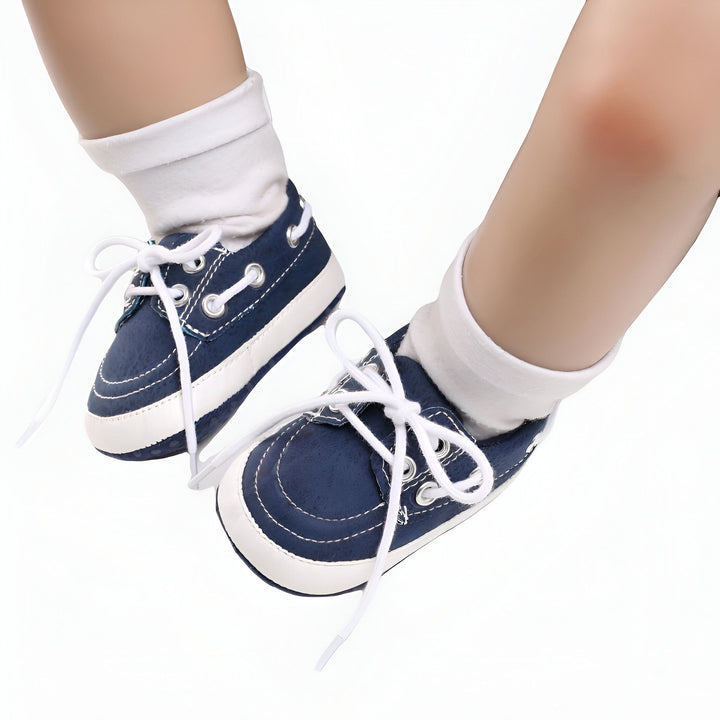 Gros plan sur les pieds d'un bébé portant des chaussettes blanches et des chaussures bateau bleu marine à lacets blancs. Chaussures de bébé élégantes et confortables. Mode infantile., 45286825787573,45286825820341,45286825853109,45286825885877,45286825918645,45286825951413,45286825984181,45286826016949,45286826049717,45286826082485,45286826115253,45286826148021