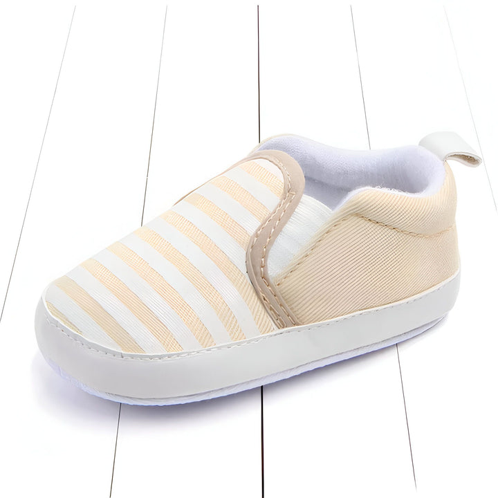 Chaussure de bébé beige et blanche à rayures, de style slip-on, avec une semelle blanche et un intérieur doux. Vue rapprochée sur fond blanc., 45286993297589,45286993330357,45286993363125,45286993395893,45286993428661,45286993461429,45286993494197,45286993526965,45286993559733