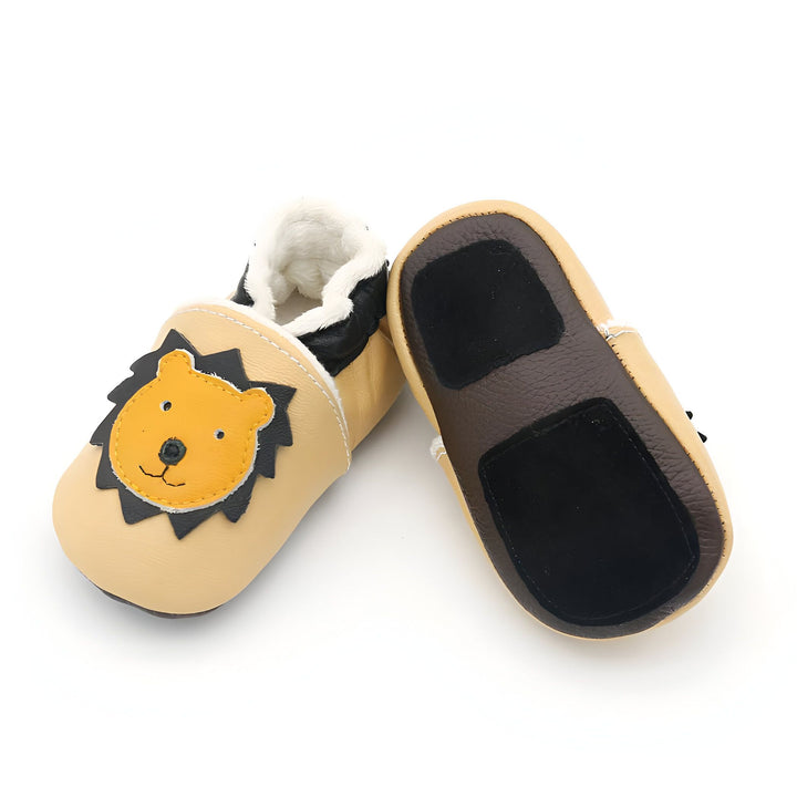 Chaussons pour bébé en cuir beige avec doublure blanche duveteuse. L'un des chaussons a une image de lion jaune avec une crinière noire. Les semelles sont marron avec des patchs noirs., 45286949683381,45286949716149,45286949748917,45286949781685,45286949814453,45286949847221,45286949879989,45286949912757,45286949945525,45286949978293,45286950011061,45286950043829,45286950076597,45286950109365,45286950142133,45286950174901,45286950207669,45286950240437,45286950273205,45286950305973