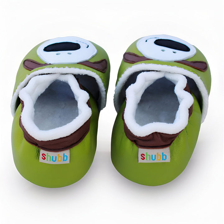Chaussons pour bébé verts avec un visage de monstre rigolo. Chaussures souples et confortables pour les petits pieds. Idéal pour les premiers pas. Marque "Shubb" visible., 45286949683381,45286949716149,45286949748917,45286949781685,45286949814453,45286949847221,45286949879989,45286949912757,45286949945525,45286949978293,45286950011061,45286950043829,45286950076597,45286950109365,45286950142133,45286950174901,45286950207669,45286950240437,45286950273205,45286950305973