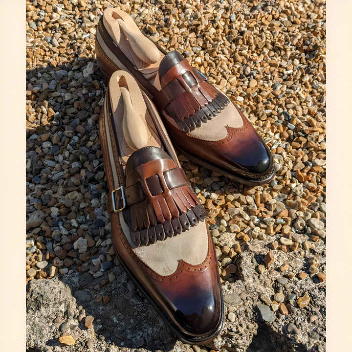 Image de deux mocassins à glands marron et beige, avec des embauchoirs en bois à l'intérieur, posés sur des galets. Chaussures de luxe pour hommes, style classique et élégant., 45286995460277,45286995493045,45286995525813,45286995558581,45286995591349,45286995624117,45286995656885,45286995689653,45286995722421,45286995755189,45286995787957,45286995820725,45286995853493,45286995886261,45286995919029,45286995951797,45286995984565,45286996017333