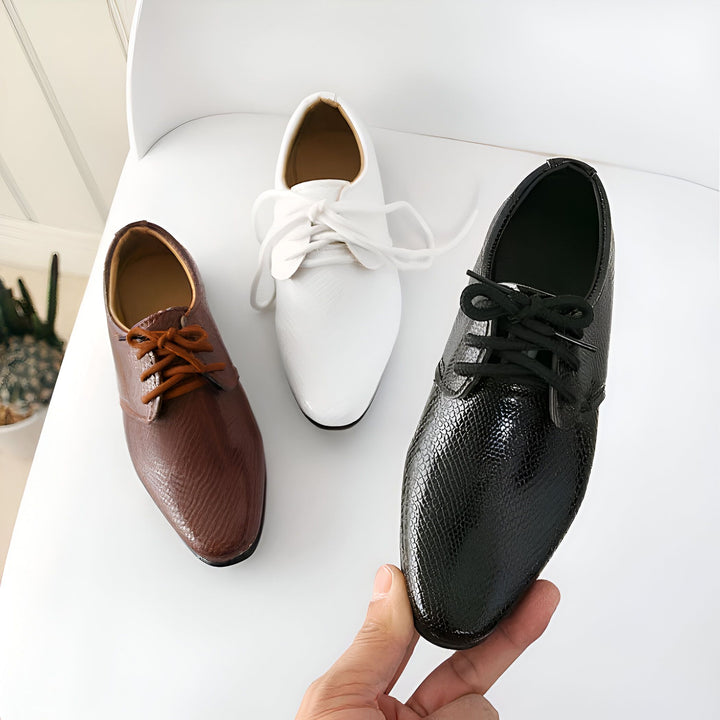 Trois chaussures habillées pour hommes sur une chaise blanche. Une chaussure marron à lacets, une chaussure blanche à lacets, et une chaussure noire à texture peau de serpent, tenue par une main. Mode masculine, chaussures élégantes, chaussures de soirée., 45287021674677,45287021707445,45287021740213,45287021772981,45287021805749,45287021838517,45287021871285,45287021904053,45287021936821,45287021969589,45287022002357,45287022035125,45287022067893,45287022100661,45287022133429,45287022166197,452870