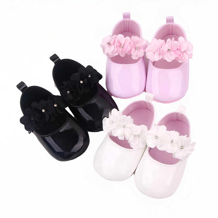 Chaussures pour bébé vernies avec des fleurs décoratives. On voit une paire noire, une paire rose et une paire blanche. Accessoires de mode pour nourrissons., 45286846365877,45286846398645,45286846431413,45286846464181,45286846496949,45286846529717,45286846562485,45286846595253,45286846628021