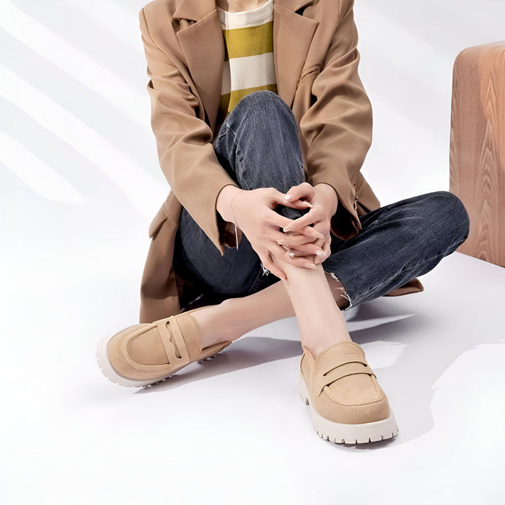 Une femme assise, portant un blazer marron, un jean noir et des mocassins beiges à semelles épaisses. Ses mains sont croisées. Style décontracté, mode automne., 45286919241909,45286919274677,45286919307445,45286919340213,45286919372981,45286919405749,45286919438517,45286919471285,45286919504053,45286919536821,45286919569589,45286919602357,45286919635125,45286919667893,45286919700661,45286919733429,45286919766197,45286919798965,45286919831733,45286919864501,45286919897269,45286919930037,45286919962805