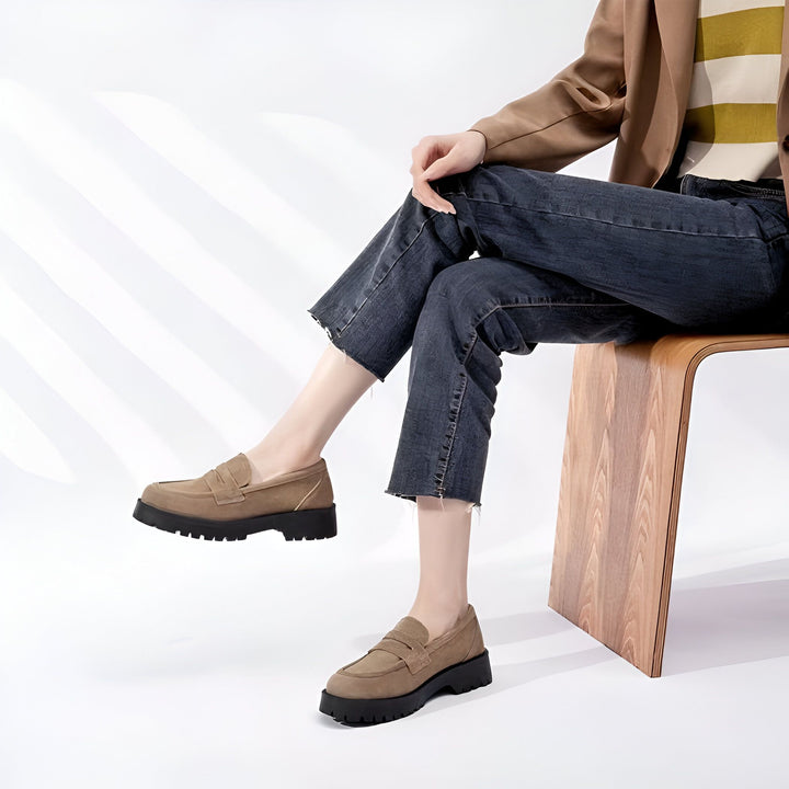 Une femme assise sur une chaise en bois, portant des mocassins marron à semelles épaisses noires et un jean court noir délavé. Elle porte également un blazer marron et un haut rayé., 45286919241909,45286919274677,45286919307445,45286919340213,45286919372981,45286919405749,45286919438517,45286919471285,45286919504053,45286919536821,45286919569589,45286919602357,45286919635125,45286919667893,45286919700661,45286919733429,45286919766197,45286919798965,45286919831733,45286919864501,45286919897269,452869
