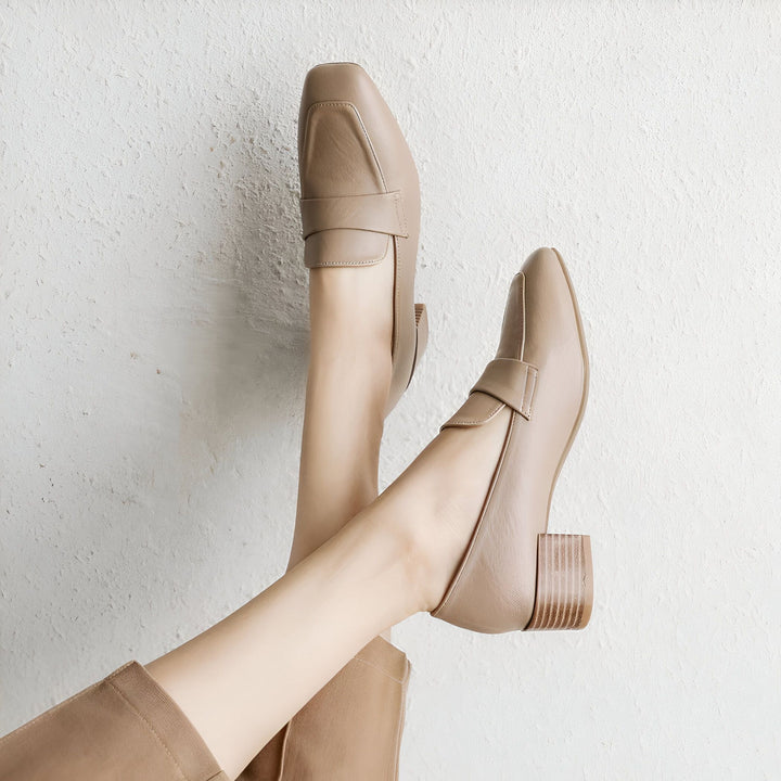 Gros plan de pieds portant des mocassins beiges à talons carrés en cuir, sur fond blanc texturé. Style élégant et tendance, chaussures confortables et modernes. Détail de la boucle sur le dessus. Accessoire de mode pour femme., 45286903906485,45286903939253,45286903972021,45286904004789,45286904037557,45286904070325,45286904103093,45286904135861,45286904168629,45286904201397,45286904234165,45286904266933,45286904299701,45286904332469,45286904365237,45286904398005,45286904430773,45286904463541,452869