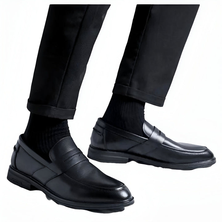 Gros plan sur les pieds d'un homme portant un pantalon noir et des mocassins en cuir noir, avec des chaussettes noires. Le style est élégant et formel. Détails sur la texture du cuir et du tissu., 45286715556021,45286715588789,45286715621557,45286715654325,45286715687093,45286715719861,45286715752629