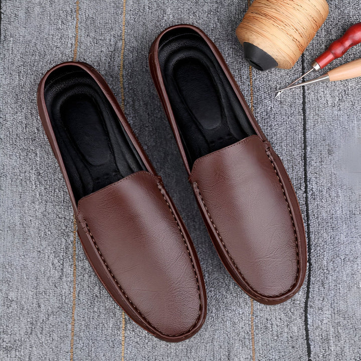 Mocassins en cuir marron pour hommes, posés sur un tapis gris avec une bobine de fil et des outils de cordonnerie à proximité. Chaussures élégantes et artisanales., 45287131709621,45287131742389,45287131775157,45287131807925,45287131840693,45287131873461,45287131906229,45287131938997,45287131971765,45287132004533,45287132037301,45287132070069,45287132102837,45287132135605,45287132168373,45287132201141,45287132233909,45287132266677,45287132299445,45287132332213,45287132364981