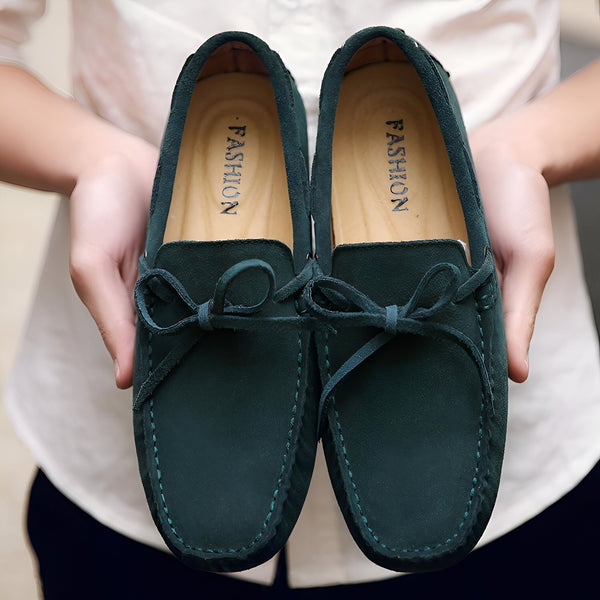 Deux mocassins verts en daim, tenus par une personne. Les chaussures ont un nœud décoratif et le mot "FASHION" est imprimé à l'intérieur. Chaussures élégantes et confortables., 45287105790133,45287105822901,45287105855669,45287105888437,45287105921205,45287105953973,45287105986741,45287106019509,45287106052277,45287106085045,45287106117813,45287106150581,45287106183349,45287106216117,45287106248885,45287106281653,45287106314421,45287106347189,45287106379957,45287106412725,45287106445493,45287106478