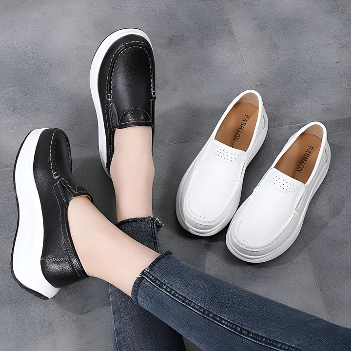 Vue rapprochée de mocassins à semelle compensée en cuir noir et blanc, portés avec un jean. Paire de mocassins blancs à côté. Chaussures confortables et tendance., 45286645989557,45286646022325,45286646055093,45286646087861,45286646120629,45286646153397,45286646186165,45286646218933,45286646251701,45286646284469,45286646317237,45286646350005,45286646382773,45286646415541