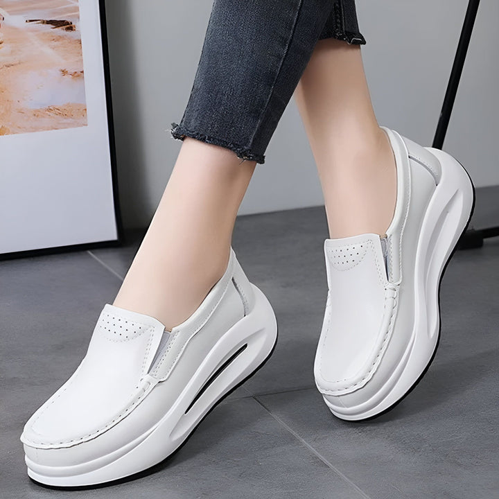 Image de gros plan d'une femme portant des chaussures blanches à plateforme compensée. Les chaussures sont en cuir avec des détails perforés et portées avec un jean gris délavé., 45286645989557,45286646022325,45286646055093,45286646087861,45286646120629,45286646153397,45286646186165,45286646218933,45286646251701,45286646284469,45286646317237,45286646350005,45286646382773,45286646415541