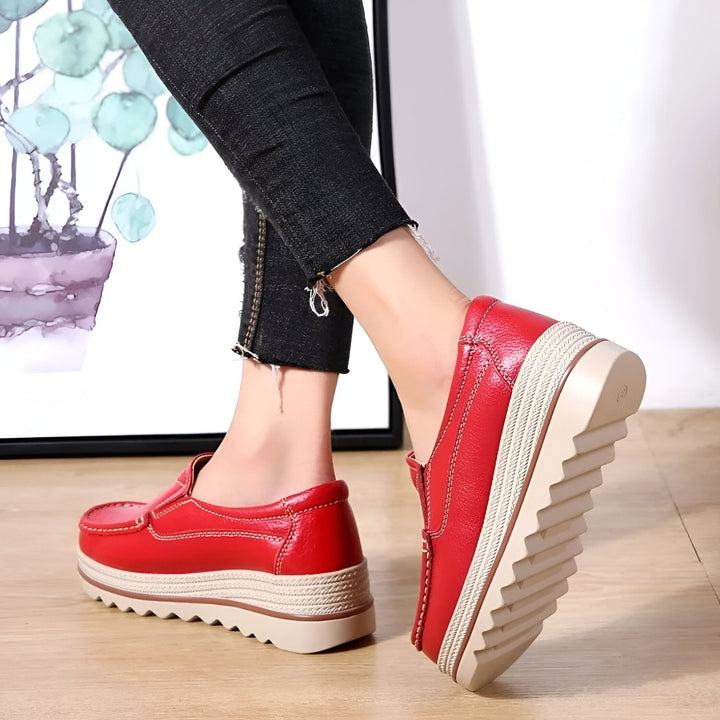 Vue rapprochée de mocassins compensés rouges portés avec un jean noir. Chaussures en cuir rouge avec semelle beige et blanche. Style décontracté et confortable., 45286649888949,45286649921717,45286649954485,45286649987253,45286650020021,45286650052789,45286650085557,45286650118325,45286650151093,45286650183861,45286650216629,45286650249397,45286650282165,45286650314933,45286650347701,45286650380469,45286650413237,45286650446005,45286650478773,45286650511541,45286650544309,45286650577077,4528665060984