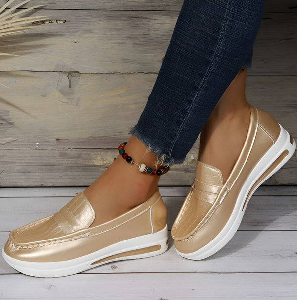 Gros plan de mocassins dorés à semelles blanches portés avec un jean et une cheville ornée d'une chaîne colorée. Chaussures de confort décontractées., 45286870778037,45286870810805,45286870843573,45286870876341,45286870909109,45286870941877,45286870974645,45286871007413,45286871040181,45286871072949,45286871105717,45286871138485,45286871171253,45286871204021,45286871236789,45286871269557,45286871302325,45286871335093,45286871367861,45286871400629,45286871433397,45286871466165,45286871498933,452868